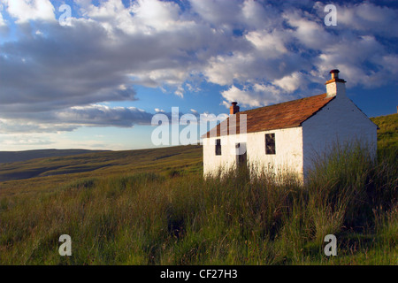 Un piccolo cottage si trova all'interno del paesaggio arido di Hartside passano vicino a Alston. Foto Stock