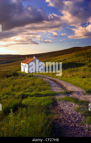 Un piccolo cottage si trova all'interno del paesaggio arido di Hartside passano vicino a Alston. Foto Stock