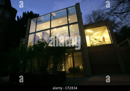 Modernista piano aperto home in Hampstead, Londra Vista dal giardino nel crepuscolo Foto Stock