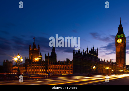 Sentieri di luce dal traffico che passa su Westminster Bridge con il Big Ben e il Parlamento in background. Foto Stock