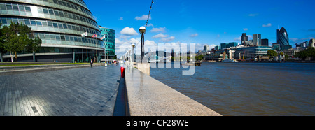 Vista lungo il Tamigi percorso verso la City Hall a south bank e la City di Londra sulla sponda nord del fiume Tamigi. Foto Stock