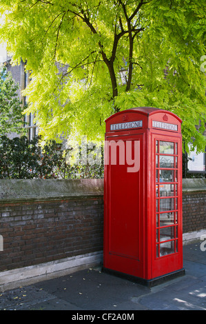 Un tradizionale telefono rosso box e la spinge contro la molla a colori in Westminster. Foto Stock