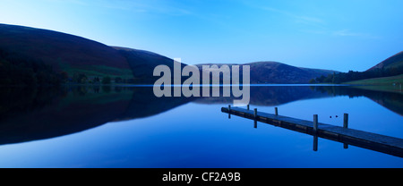 St Marys Loch al tramonto, con le colline circostanti e lakeside jetty riflessa nelle acque ferme del Loch. Foto Stock