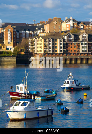 Barche ormeggiate sul fiume Tyne con un complesso di appartamenti di nuova costruzione situato sulla North Shields Quayside in distanza. Foto Stock