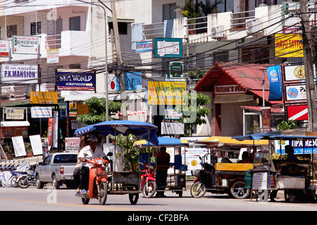 Un motociclo taxi crociere lungo una strada principale nella città di Ao Nang, Provincia di Krabi, Thailandia. Foto Stock