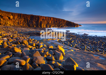 Alba la luce illumina il litorale roccioso del punto Cullernose, nei pressi del villaggio di Craster sul patrimonio di Northumberland Coast Foto Stock