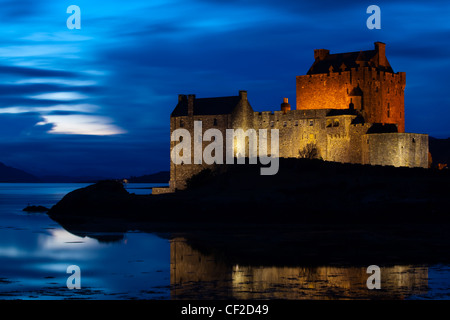 Eilean Donan Castle riflessa nelle acque ancora di Loch Duich al crepuscolo. Foto Stock