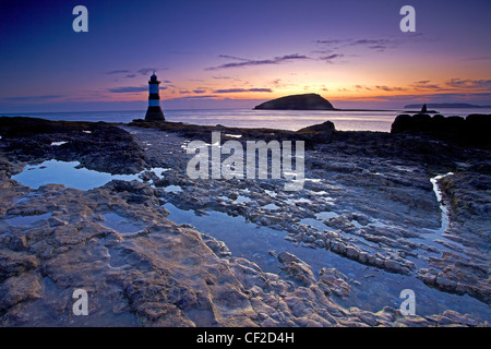 Faro Penmon, noto anche come Menai faro, all'ingresso nord della Menai Strait di fronte Puffin Island all'alba. Foto Stock