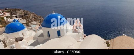 Una vista panoramica del villaggio di due chiese con blu cupole dipinte e un dipinto di rosa torre campanaria Foto Stock