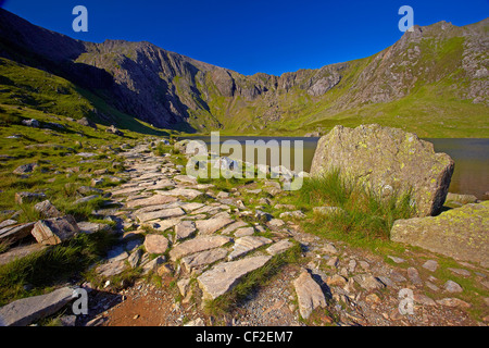 Vista del Llyn Idwal guardando verso il diavolo in cucina il Glyderau montagne di Snowdonia. Foto Stock