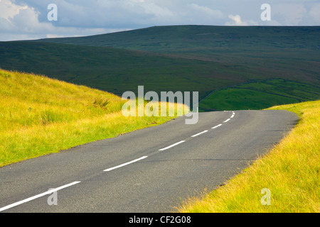 Una strada di campagna in esecuzione attraverso la drammatica Pennine scenario al North Pennines Area di straordinaria bellezza. Foto Stock