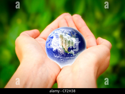 Le mani umane tenendo attentamente il pianeta Terra. Mondo di vetro Foto Stock