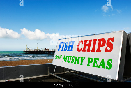 Un segno pubblicità pesce e patatine con fiacco piselli sul lungomare di Brighton. Foto Stock