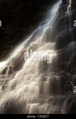 Hareshaw Linn è una spettacolare cascata che si trova in una ripida gola unilaterale, che continua a fluire attraverso una valle boscosa. Haresh Foto Stock