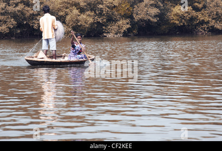 Foto editoriale della donna indiana e l uomo nella piccola barca con rete da pesca. Goa in India Foto Stock