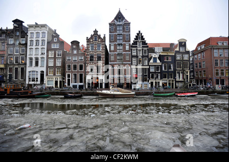 Tipici edifici di Amsterdam si affaccia su un canale congelati in Amsterdam, Paesi Bassi. Foto Stock