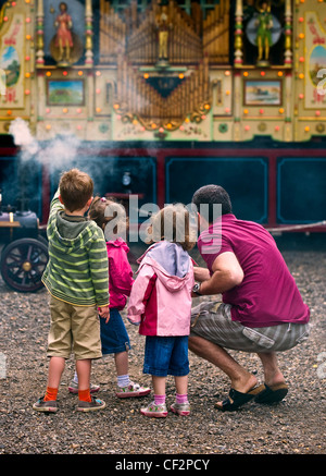 Padre e figli guardando un organo di vapore al Audley End Gala vapore 2011. Foto Stock