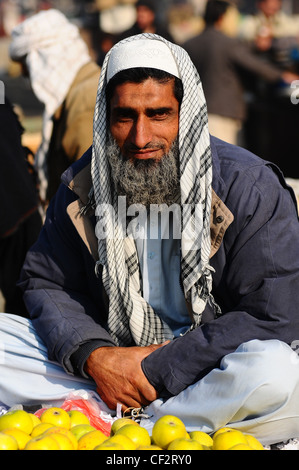 Un venditore con una barba grigia al subzi mandi (ingrosso di frutta e verdura del mercato) a Islamabad, Pakistan Foto Stock