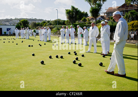 Giocatori vestito di bianco riproduzione verde corona bocce a Newlyn Bowling Club. Foto Stock