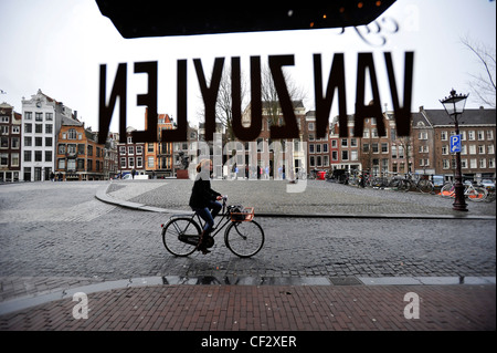 Un ciclista passa alla finestra del Cafe Van Zuylen in Amsterdam, Paesi Bassi. Foto Stock