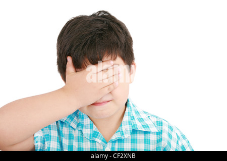 Ritratto di pianto triste ragazzino si copre il viso con la sua mano Foto Stock