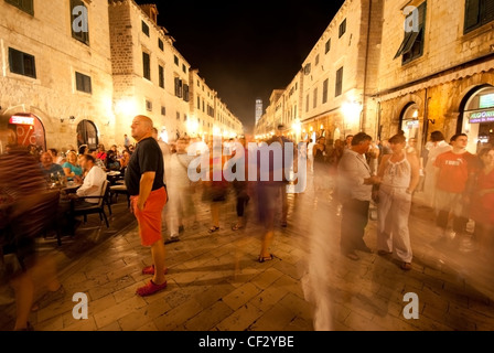 Una vista giù per la strada principale a Dubrovnik di notte con la gente vivace attraverso la scena Foto Stock