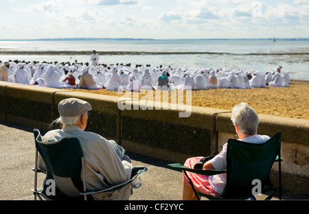 Due anziani seduti nelle sedie sul lungomare a guardare la congregazione di una chiesa apostolica adorante sul Giubileo Bea Foto Stock