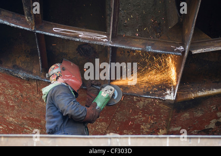 Lavorando sul lato inferiore di un peschereccio, Macduff, Aberdeenshire, Scozia. Foto Stock