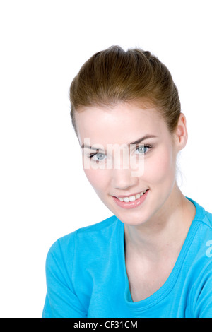 Femmina con capelli castani fuori la sua faccia, indossando un turchese top, sorridente, guardando la fotocamera Foto Stock