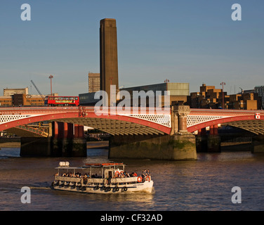 Una gita in barca in viaggio sotto il Blackfriars road bridge con la svettante camino della Tate Modern in background. Foto Stock