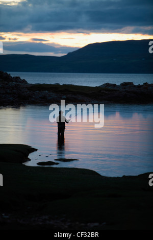 Un pescatore di Pesca a Mosca Report di Pesca in Loch Eishort al tramonto su isola di Sky. Foto Stock