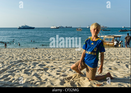 Ragazzo gioca sulla spiaggia a Tembo Hotel Stone Town Zanzibar Tanzania Foto Stock