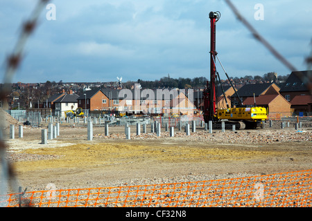 Pila driver sul sito di costruzione con colonne di cemento per la stabilità Foto Stock