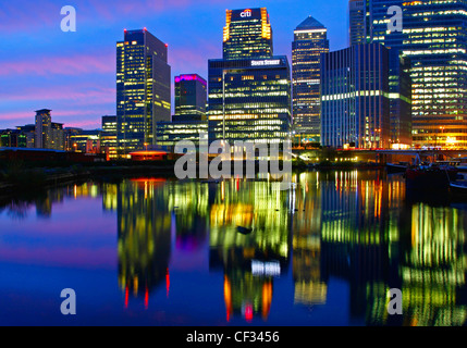 Le luci da grattacieli di Canary Wharf riflessa nel bacino di Blackwall di notte. Foto Stock