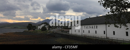 La Talisker Distillery, l'unica distilleria sull'Isola di Skye, sulle rive di Loch Harport con il Cuillins nel backgro Foto Stock