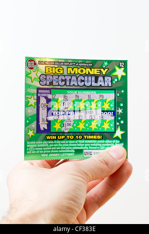 Tenendo la mano vincente lotteria scratch card di un New Jersey lottery su sfondo bianco Foto Stock