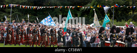 La folla guarda il marzo del clan al Lonach Highland Games. Foto Stock