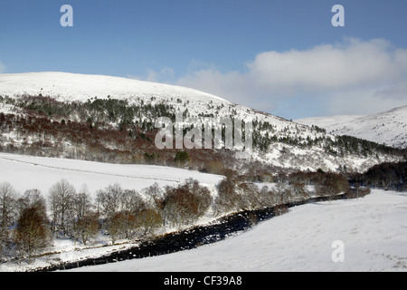Fiume Gairn in esecuzione attraverso la neve sulle colline coperte di Glen Gairn. Foto Stock