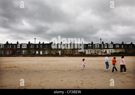 Un cielo grigio su persone che camminano sul Portobello Beach a Edimburgo. Foto Stock