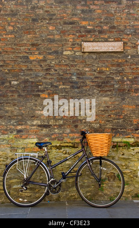 Una bicicletta appoggiata contro una parete in Cambridge. Storicamente, l'Università di Cambridge gli studenti non sono stati autorizzati a guidare anterioreè Foto Stock