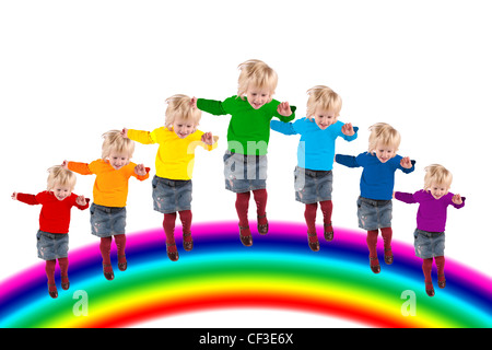 I bambini con colore arcobaleno dress saltando su rainbow, collage Foto Stock