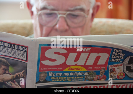 L'uomo la lettura prima edizione del sole domenica giornale scandalistico 26 Febbraio 2012 Foto Stock