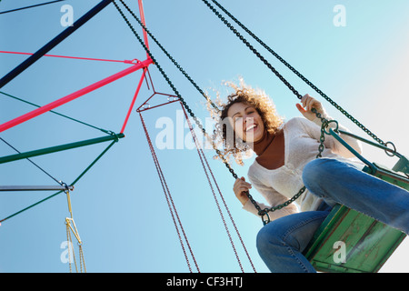 Affascinante ragazza va per guidare sulla rotatoria. Guardando nella telecamera. Foto Stock