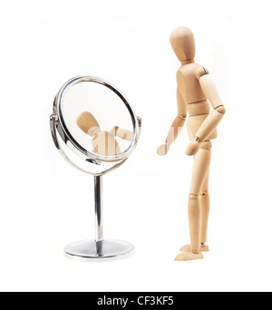 Narcisista legno mannekin guardando lo specchio su bianco Foto Stock