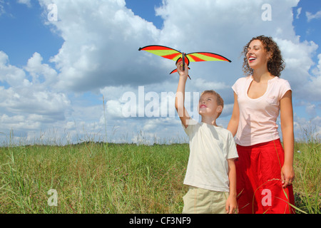 Giovane donna e bambino gioca kite sul prato Foto Stock