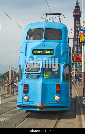 Un tram elettrici che viaggiano lungo il Blackpool del Miglio d'oro con la torre in background. Foto Stock