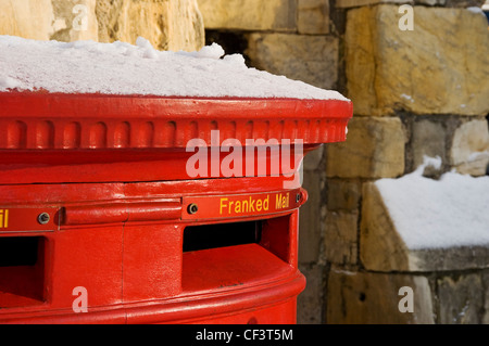 Un rosso casella postale con una spolverata di neve sulla cima di York. Foto Stock