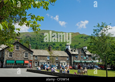 Turisti che si godono il sole estivo nel centro di Grasmere. Foto Stock