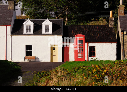 Telefono rosso scatola con villette nel villaggio di Plockton. Il villaggio dispone di National Trust lo stato di conservazione. Foto Stock