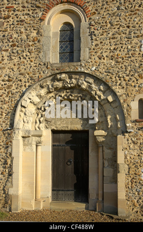 Una pietra scolpita arch al di sopra del legno ingresso doored Pleshey alla Chiesa della Santa Trinità. Foto Stock